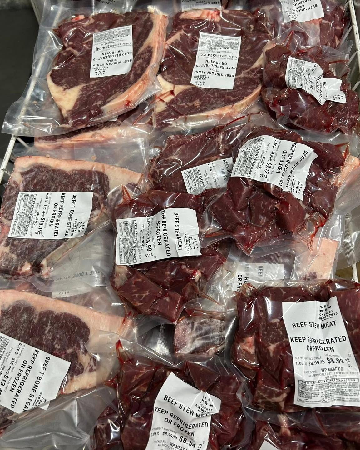Multiple vacuum-sealed packages of raw beef and veal cuts offered at WP Meat Co in Enfield, Illinois.