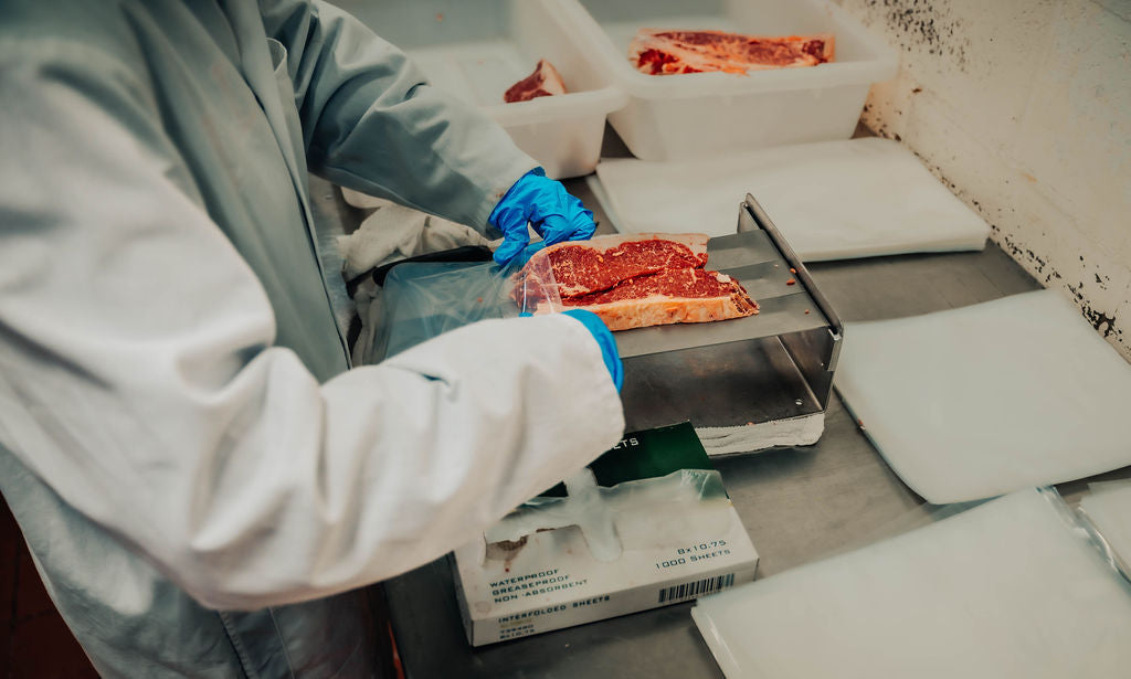 Meat processor packaging meat at WP Meat Co in Enfield, Illinois. 