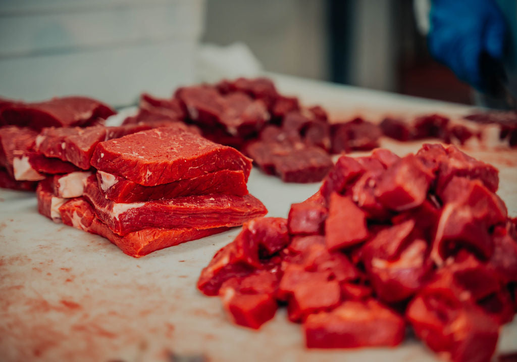 Raw red meat pieces, including stacked slices and diced chunks offered at WP Meat Co in Enfield, Illinois. 
